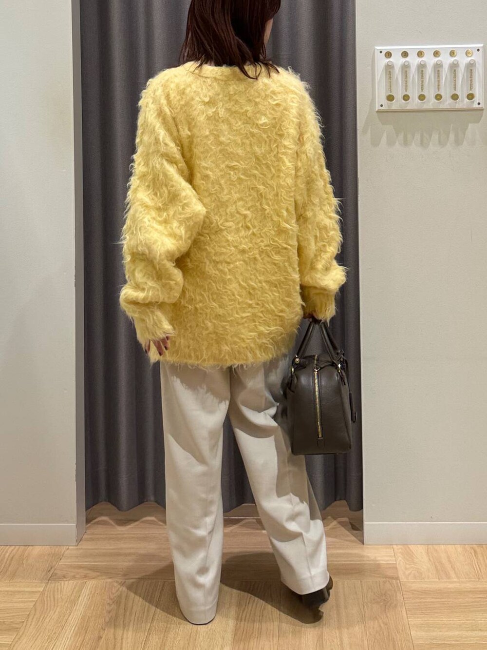 ブラウン系のハンドバッグ、イエロー系のカーディガン/ボレロ、ブラウン系のローファーを着用したレディースの秋コーディネートの5枚目の写真