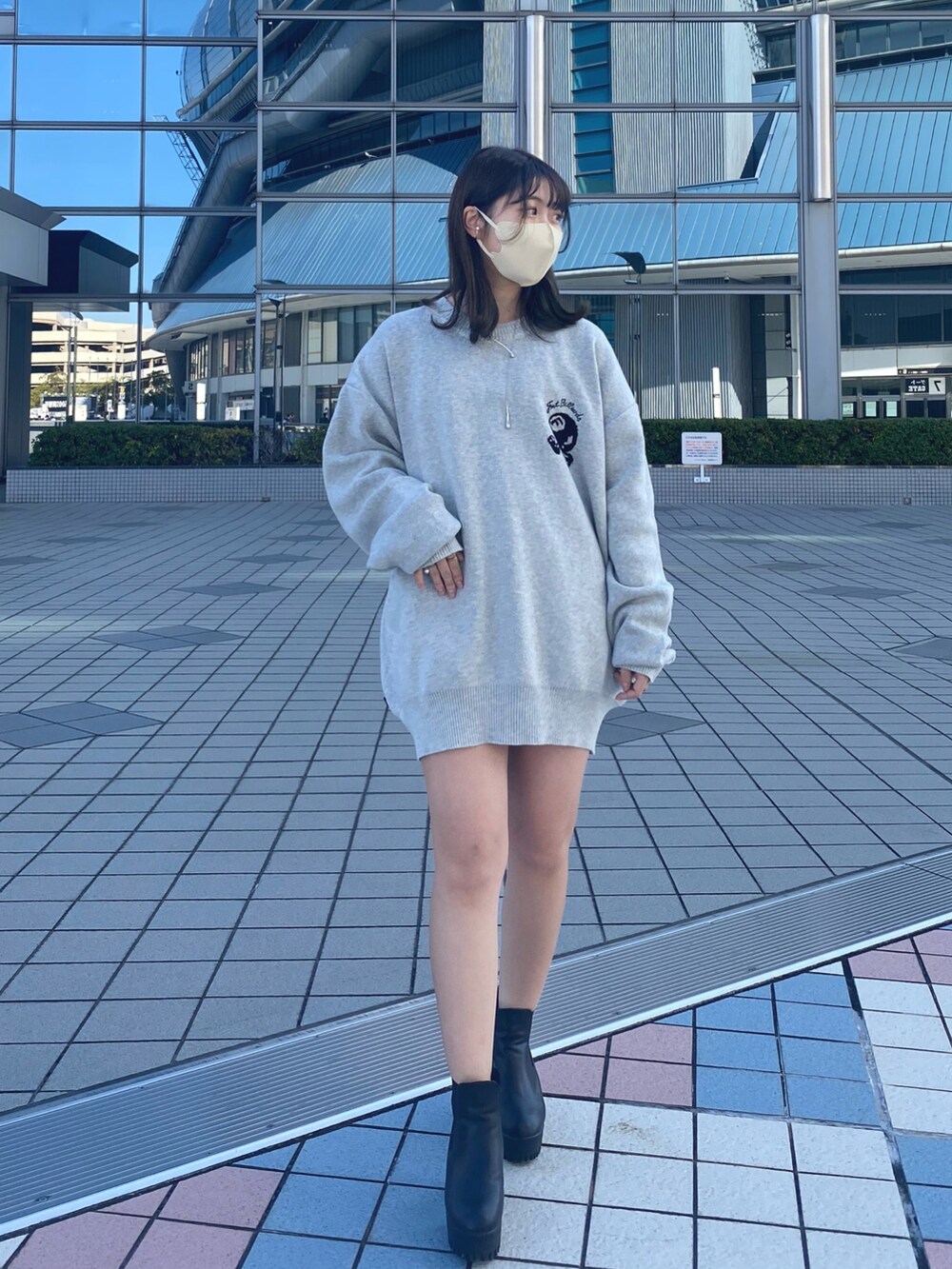 グレー系のニット/セーター、ブラック系のブーツを着用したレディースの冬コーディネートの2枚目の写真