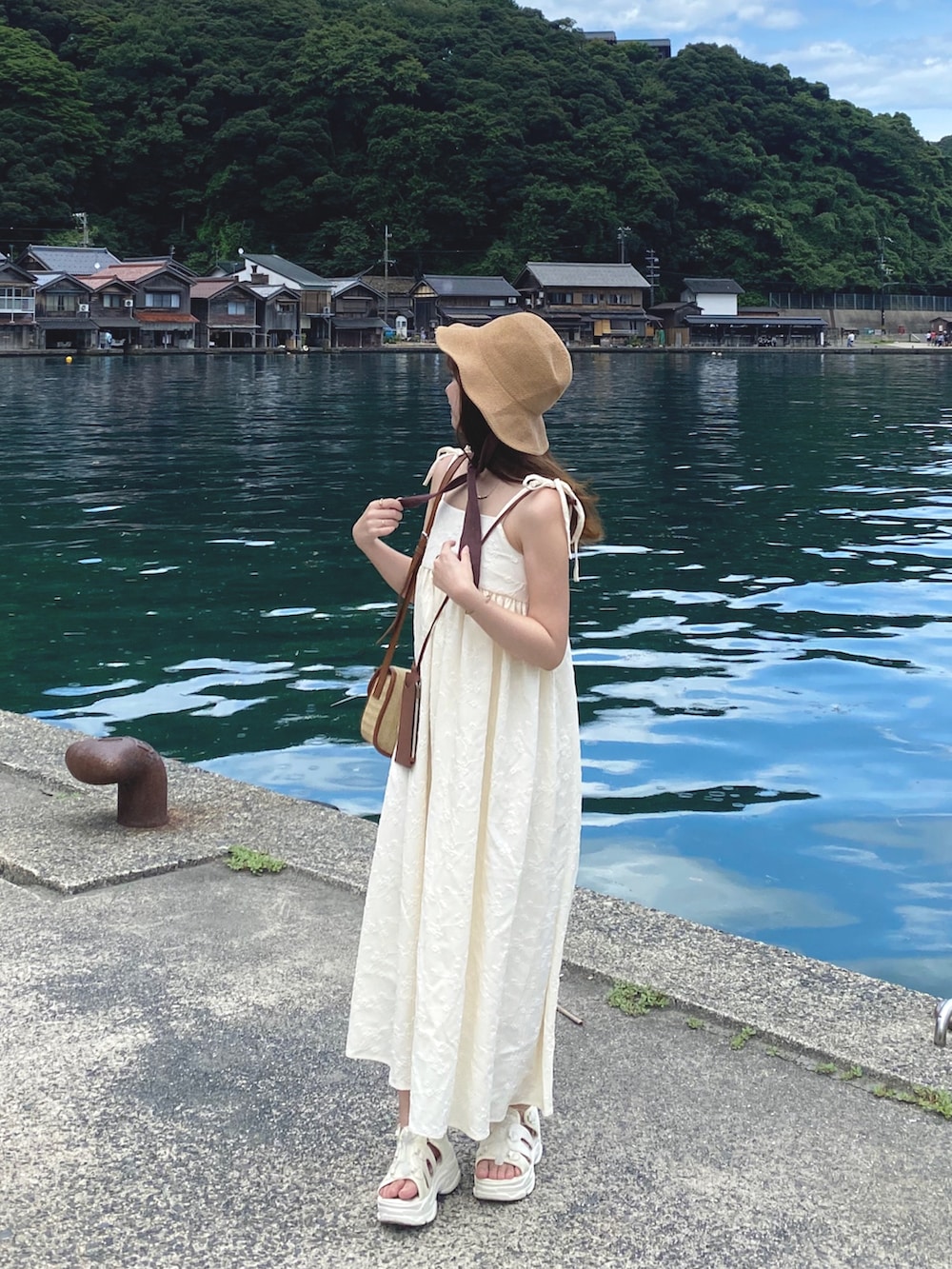 ホワイト系のワンピース/ドレス、ベージュ系のショルダーバッグ、ホワイト系のサンダルを着用したレディースの夏コーディネートの2枚目の写真