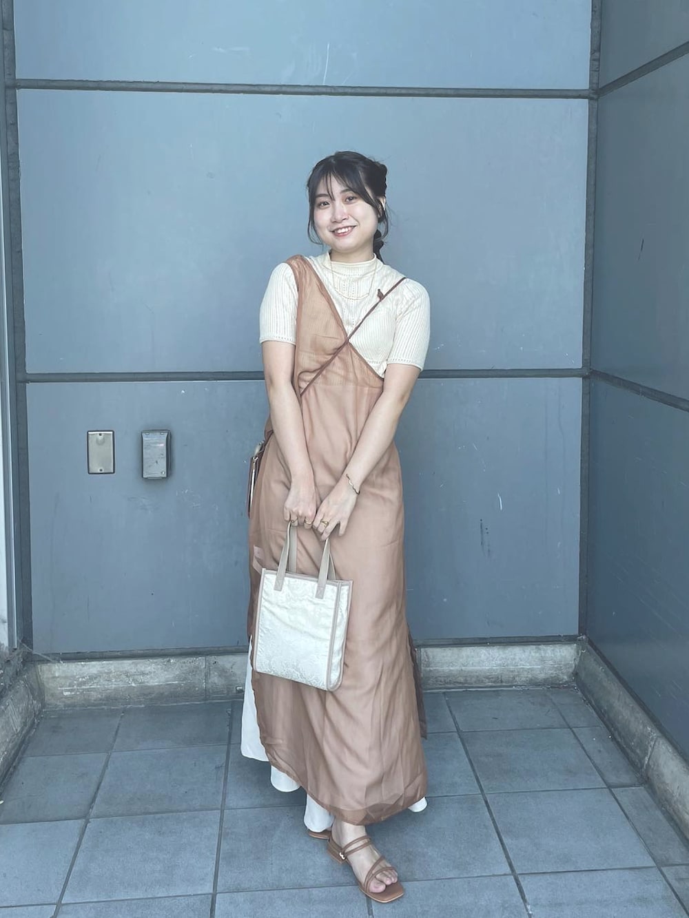 ベージュ系のワンピース、ブラウン系のサンダルを着用したレディースの夏コーディネートの2枚目の写真