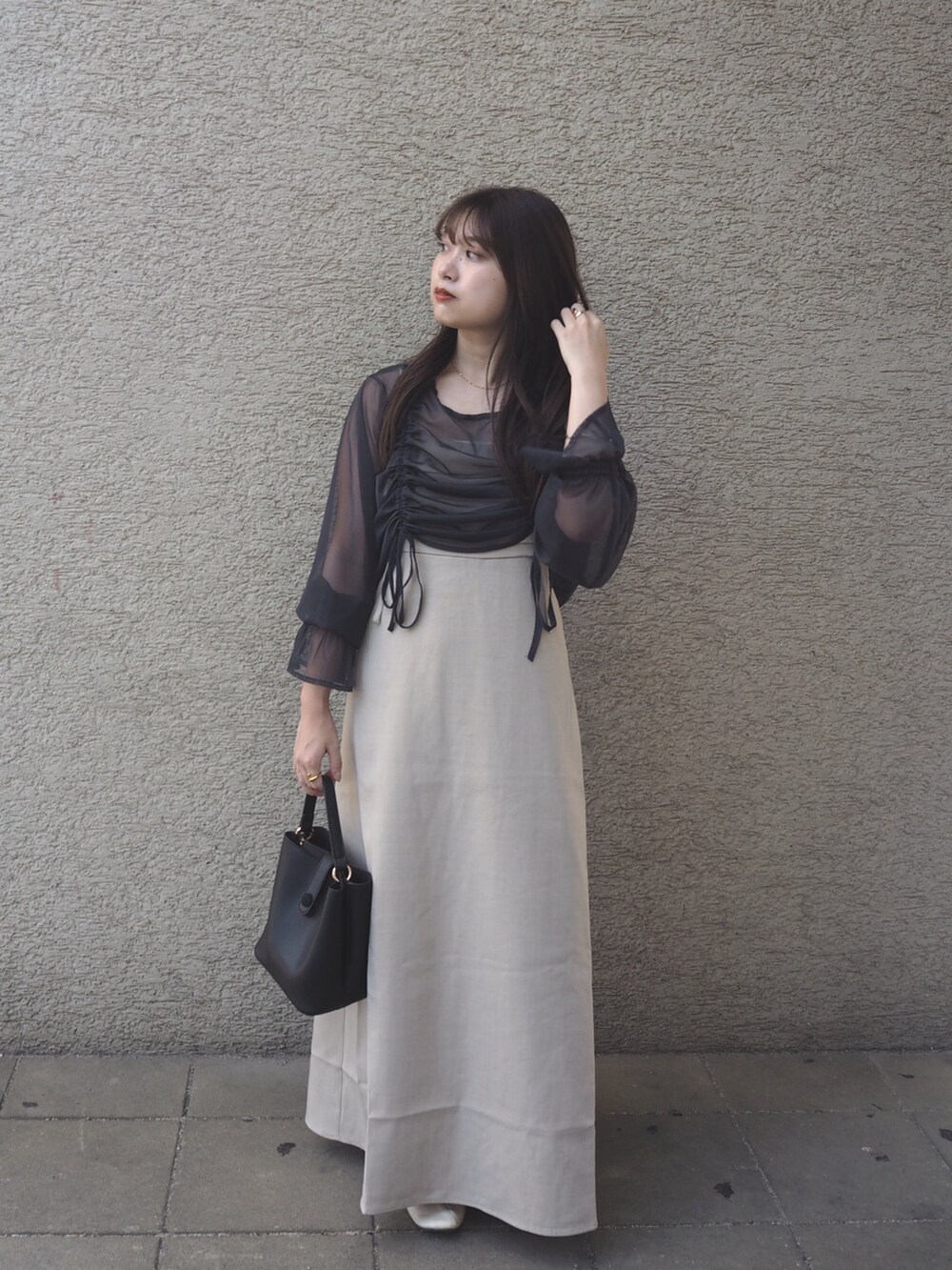 ベージュ系のワンピース、ホワイト系のパンプスを着用したレディースの秋コーディネートの2枚目の写真