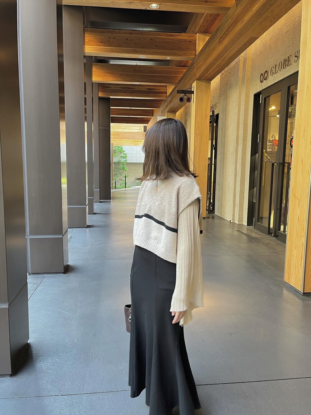 ブラウン系のショルダーバッグ、ブラック系のスカートを着用したレディースの冬コーディネートの3枚目の写真