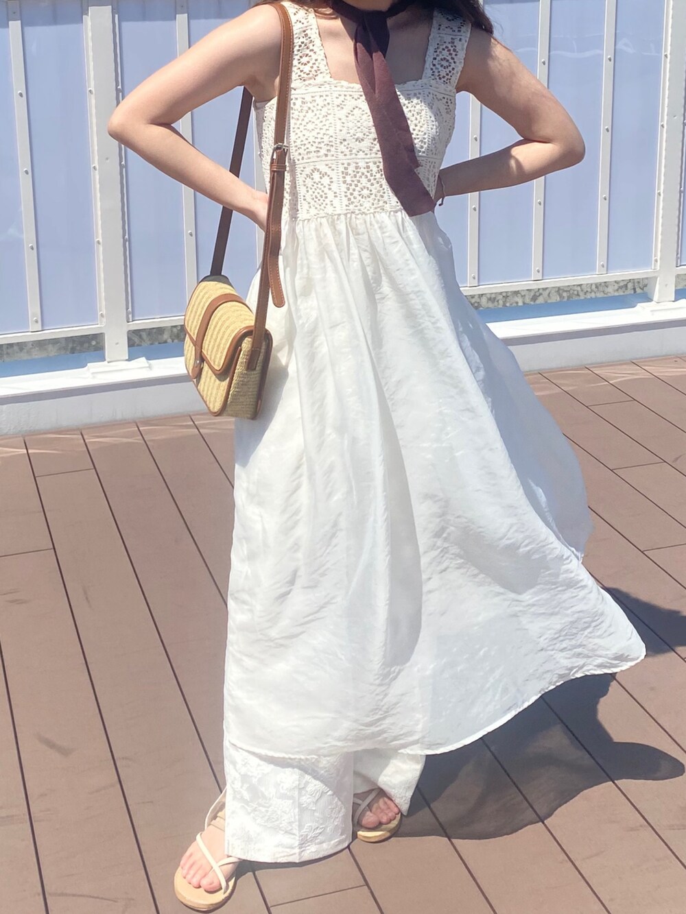 ホワイト系のワンピース、ホワイト系のスラックス、ベージュ系のショルダーバッグを着用したレディースの夏コーディネートの2枚目の写真