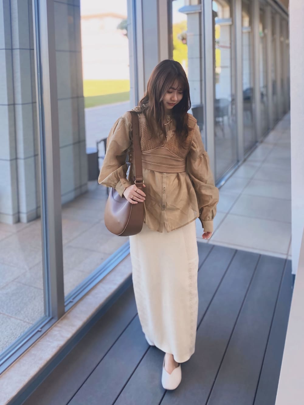 ベージュ系のシャツ/ブラウス、ホワイト系のスカート、ホワイト系のパンプスを着用したレディースの秋コーディネートの3枚目の写真