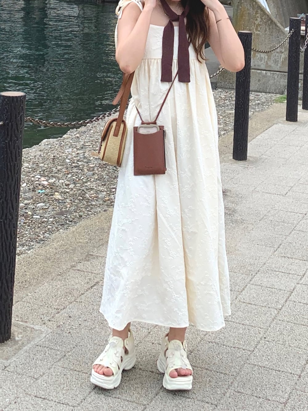 ホワイト系のワンピース/ドレス、ベージュ系のショルダーバッグ、ホワイト系のサンダルを着用したレディースの夏コーディネートの3枚目の写真