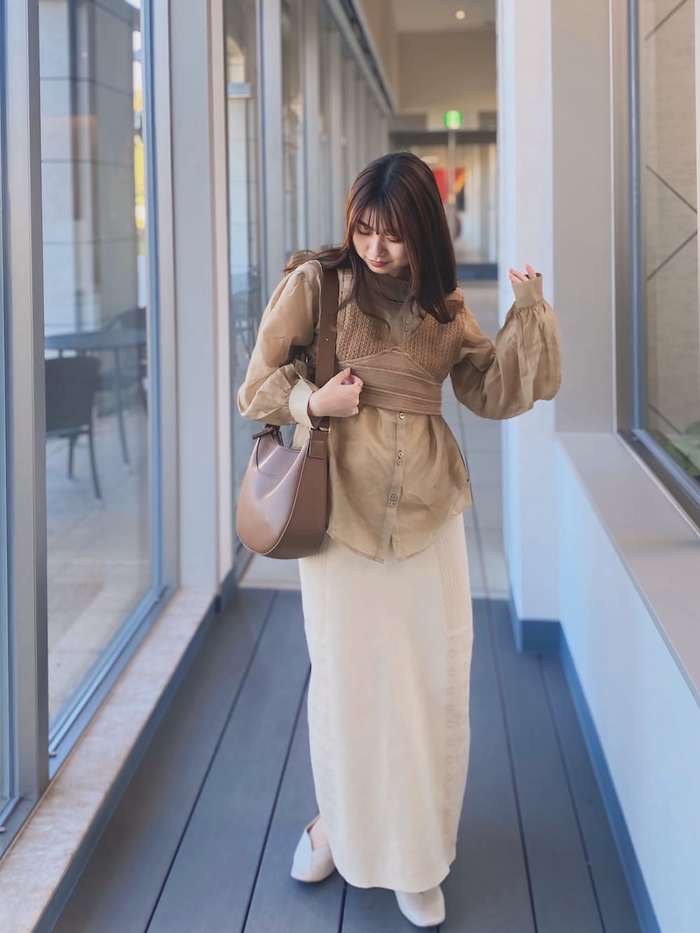 ベージュ系のシャツ/ブラウス、ホワイト系のスカート、ホワイト系のパンプスを着用したレディースの秋コーディネートの2枚目の写真