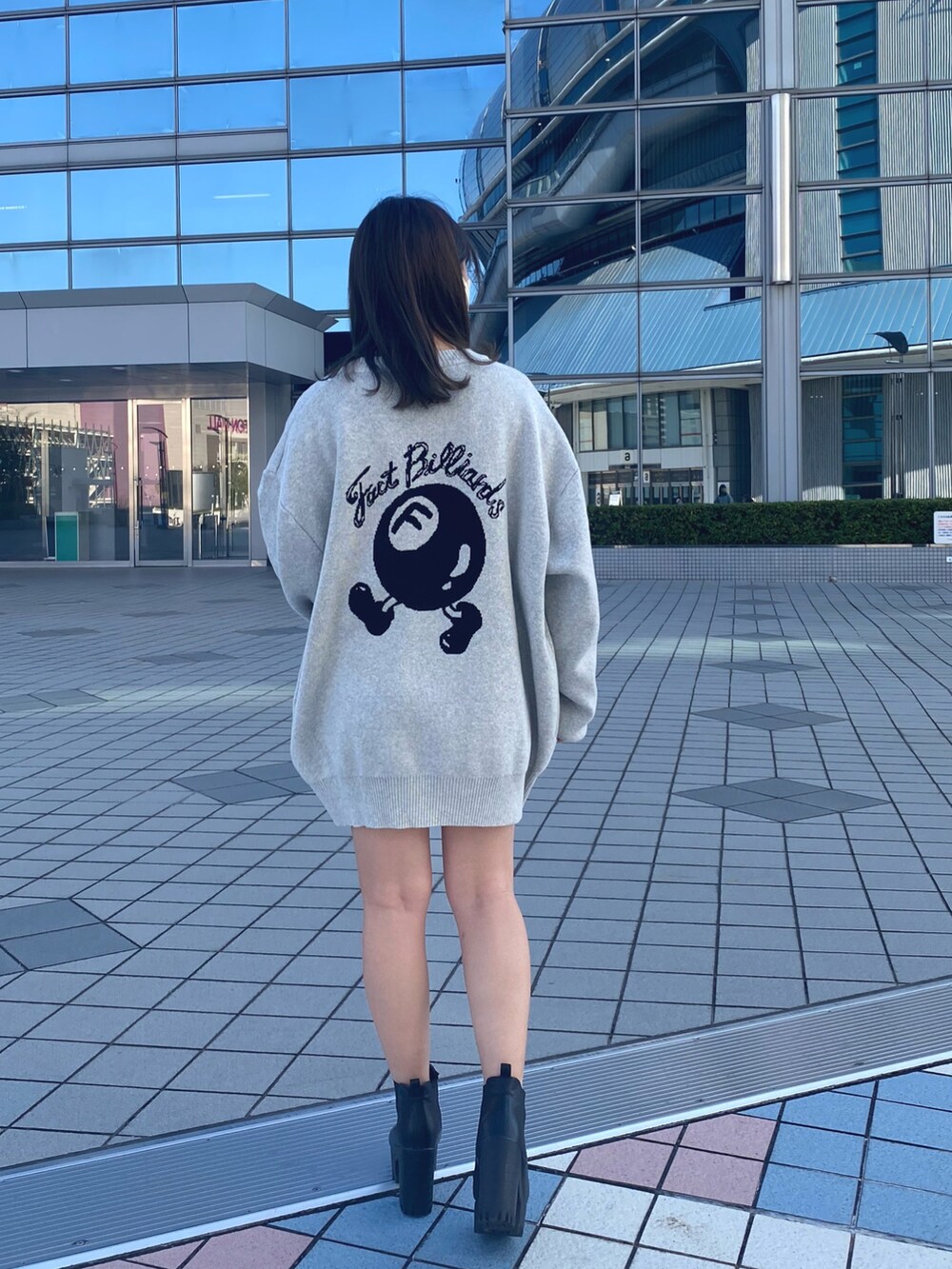 グレー系のニット/セーター、ブラック系のブーツを着用したレディースの冬コーディネートの3枚目の写真