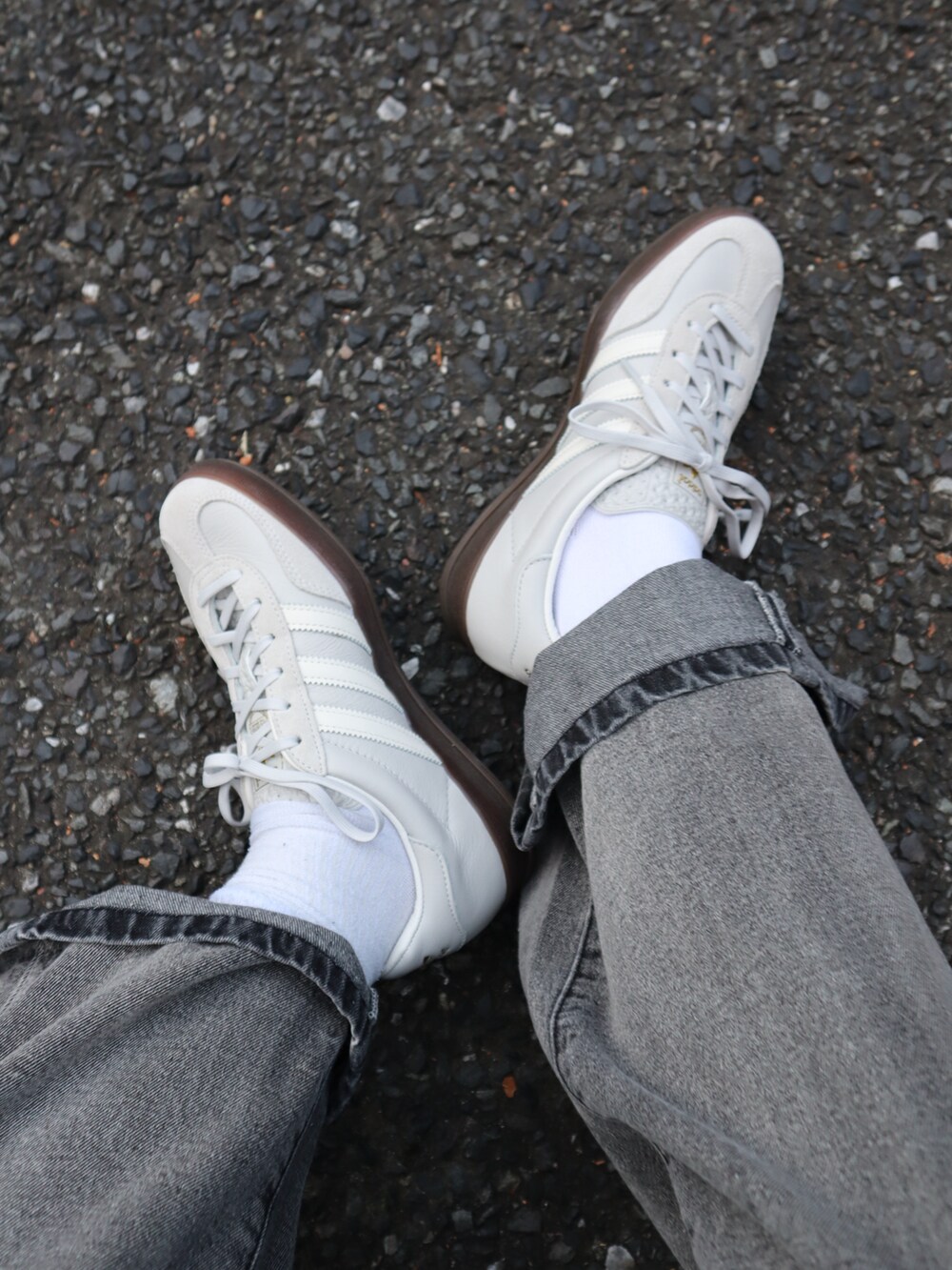 ブラック系のデニムパンツ、ブルー系のニット/セーター、グレー系のスニーカーを着用したレディースの秋コーディネートの3枚目の写真