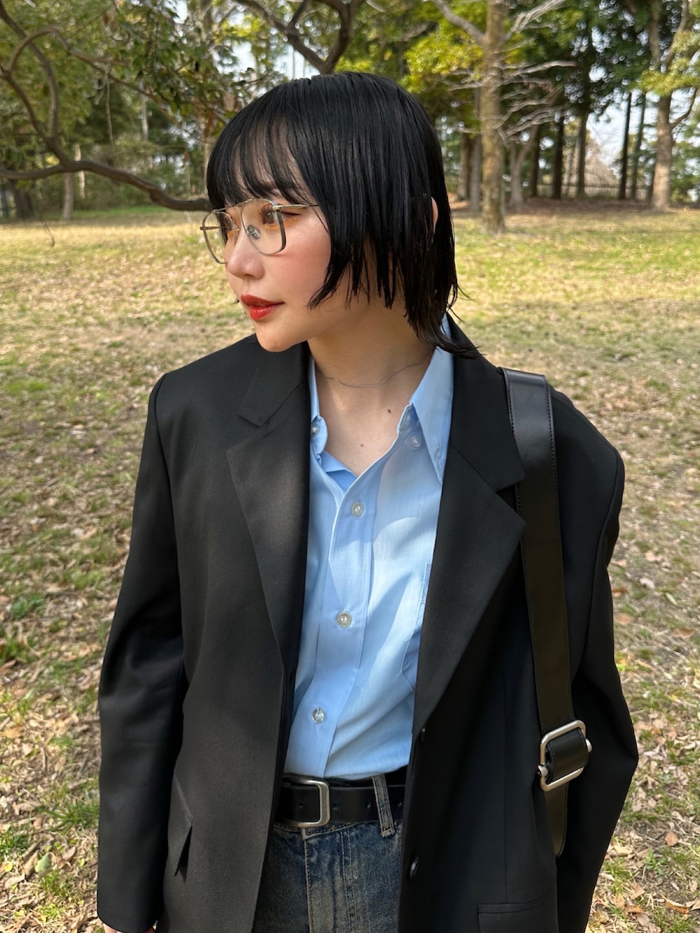 ホワイト系のスニーカー、ブルー系のデニムパンツ、ブルー系のシャツ/ブラウスを着用したレディースの春コーディネートの4枚目の写真