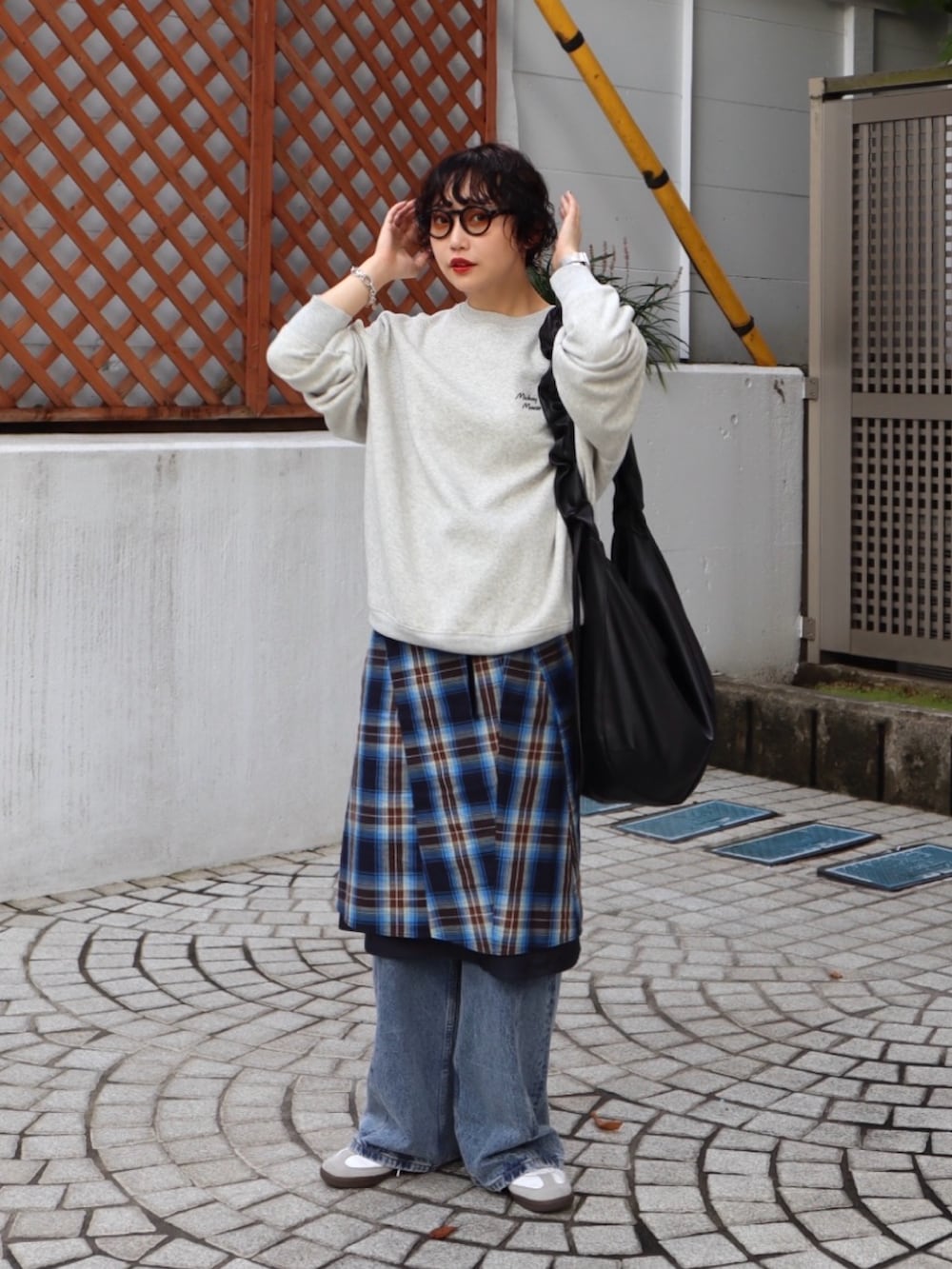 グレー系のスウェット、ブルー系のスカート、ブルー系のデニムパンツを着用したレディースの秋コーディネートの3枚目の写真