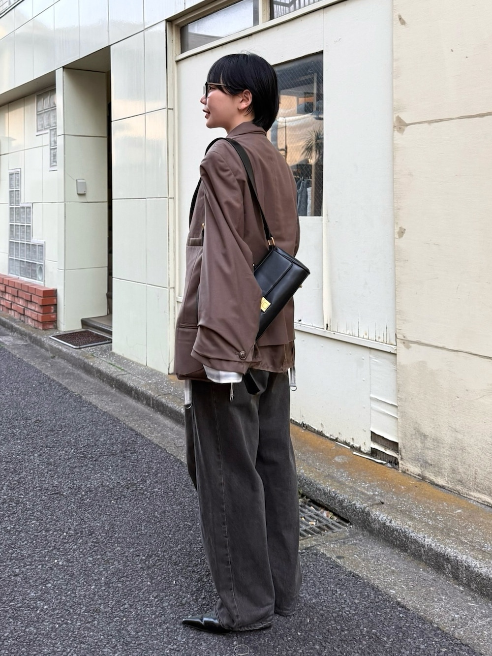 ブラック系のショルダーバッグ、ホワイト系のシャツ/ブラウス、ブラウン系のその他アウターを着用したレディースの春コーディネートの2枚目の写真