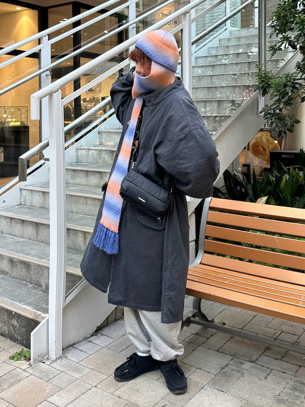 グレー系のジャケット/アウター、ブラック系のショルダーバッグ、グレー系のスウェットパンツを着用したレディースの秋コーディネートの2枚目の写真