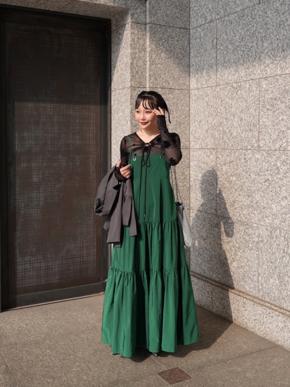 グレー系のテーラードジャケット、シルバー系のパンプス、ブラック系のトップスを着用したレディースの春コーディネートの2枚目の写真