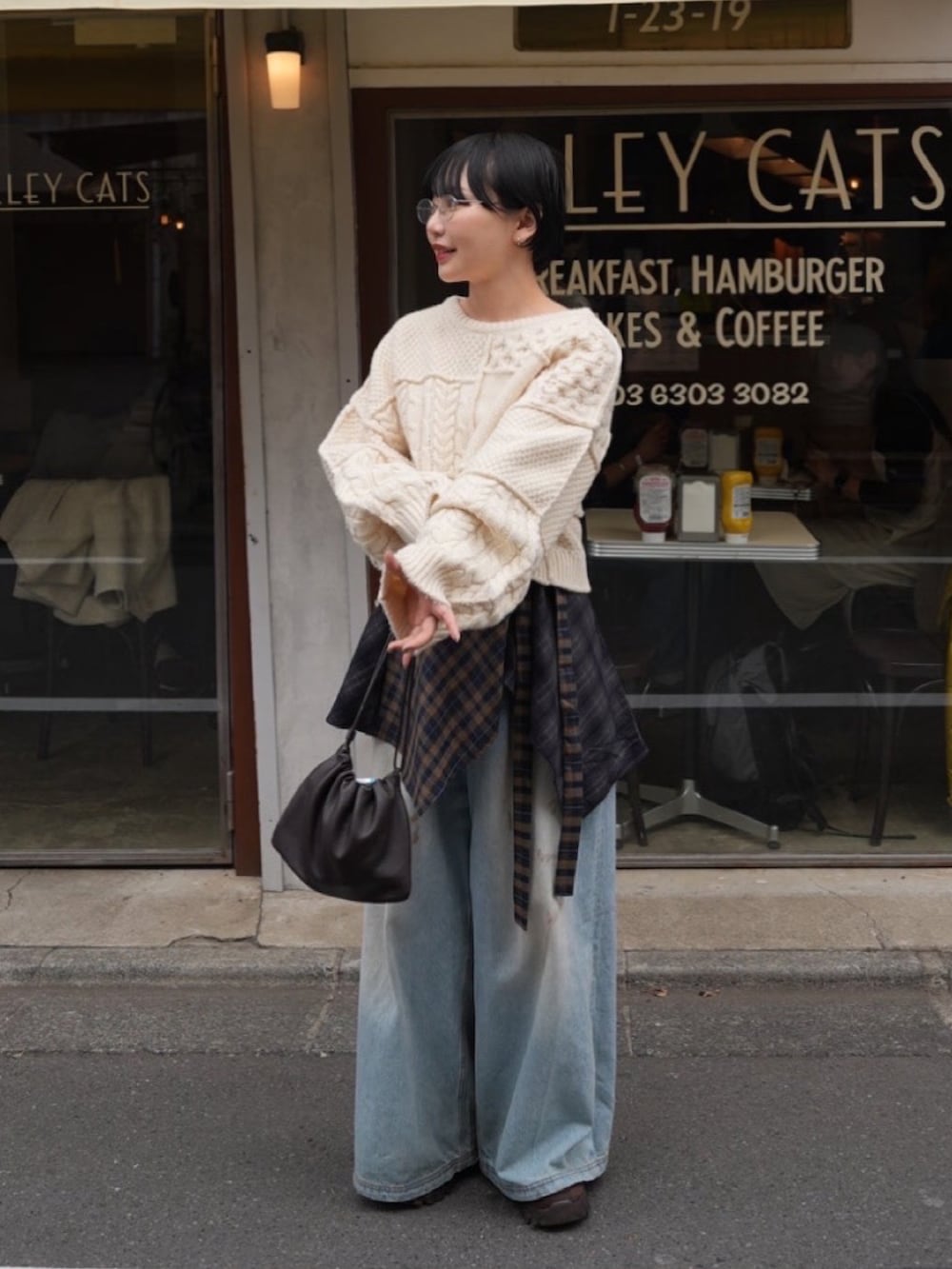 ホワイト系のトップス、ブルー系のデニムパンツ、ブラック系のデニムパンツを着用したレディースの冬コーディネートの2枚目の写真