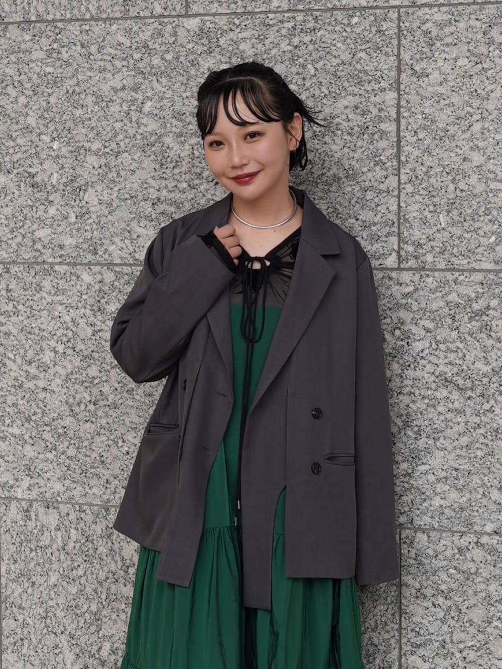 グレー系のテーラードジャケット、シルバー系のパンプス、ブラック系のトップスを着用したレディースの春コーディネートの3枚目の写真