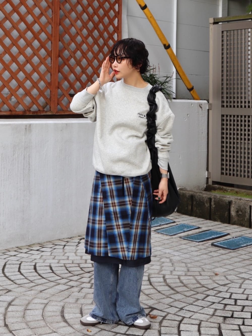 グレー系のスウェット、ブルー系のスカート、ブルー系のデニムパンツを着用したレディースの秋コーディネートの2枚目の写真