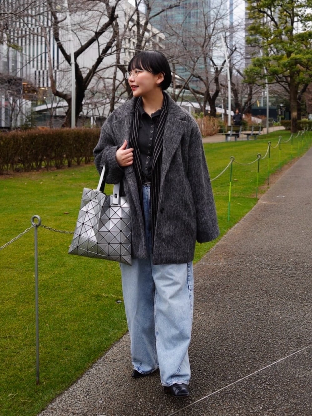 グレー系のTシャツ/カットソー、ブラック系のテーラードジャケット、ブルー系のデニムパンツを着用したレディースの冬コーディネートの3枚目の写真