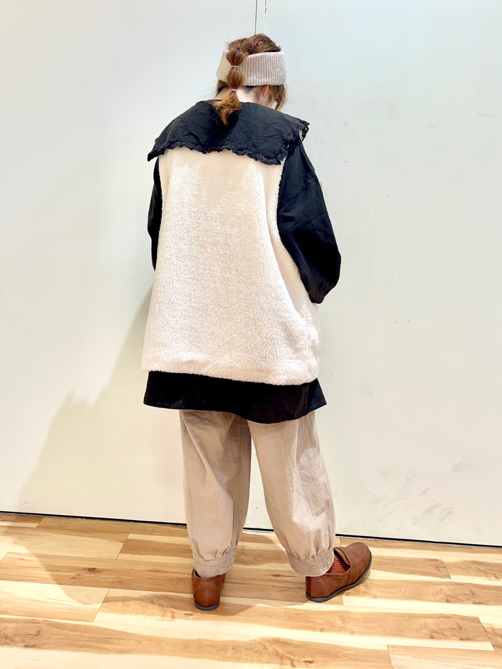 ホワイト系のベスト、ブラウン系のチュニック、ベージュ系のその他パンツを着用したレディースの秋コーディネートの2枚目の写真