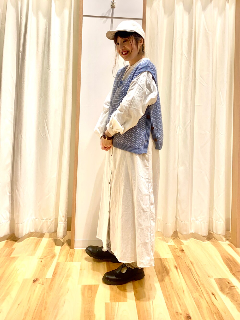 ブルー系のベスト、ホワイト系のワンピース、グレー系のその他パンツを着用したレディースの春コーディネートの3枚目の写真