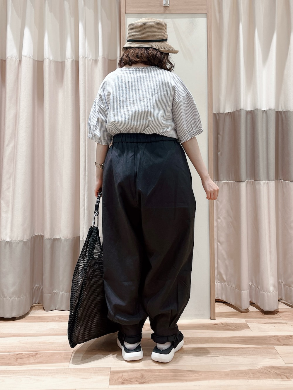 ブルー系のシャツ/ブラウス、グレー系のその他パンツ、ブラック系のハンドバッグを着用したレディースの夏コーディネートの2枚目の写真