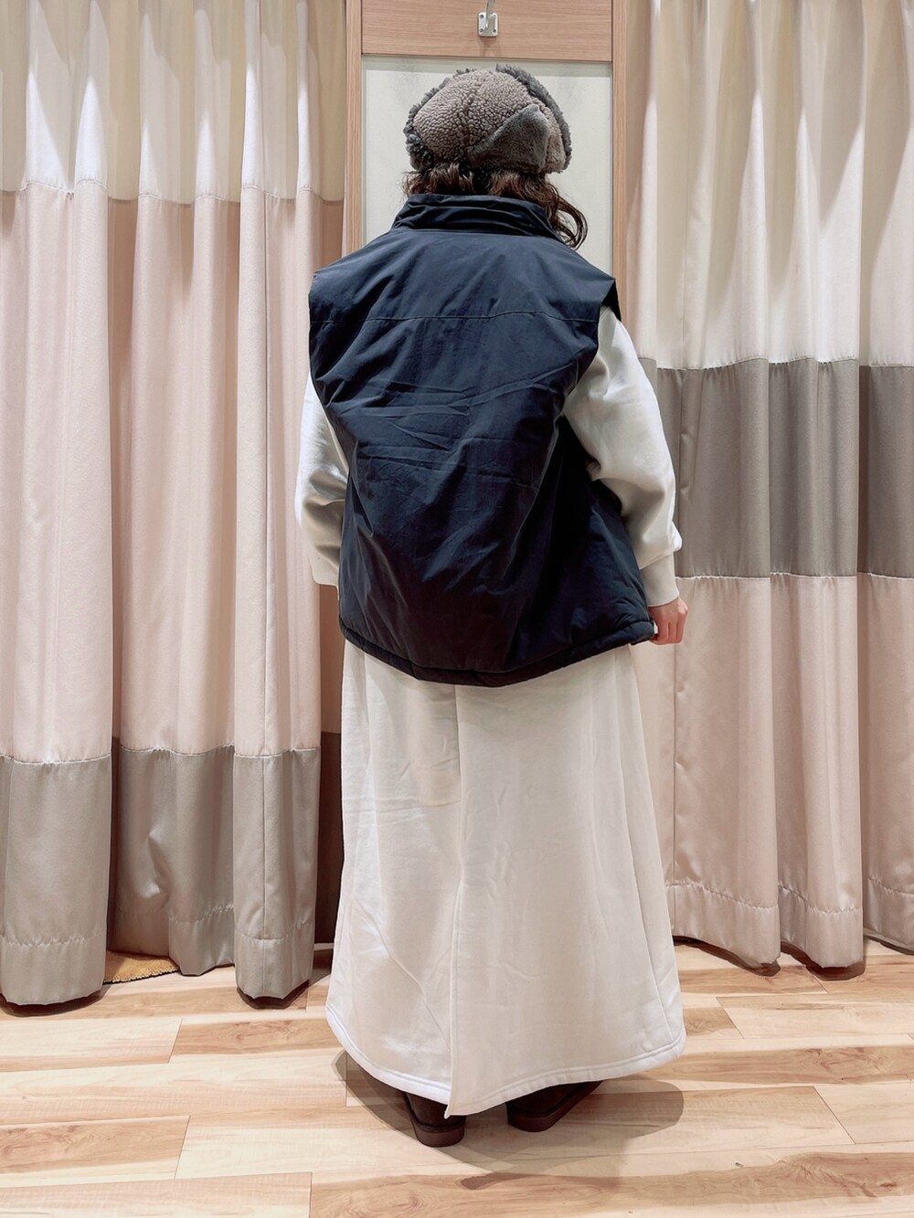 ホワイト系のワンピース、グレー系のベスト、ブラック系のニット/セーターを着用したレディースの冬コーディネートの2枚目の写真