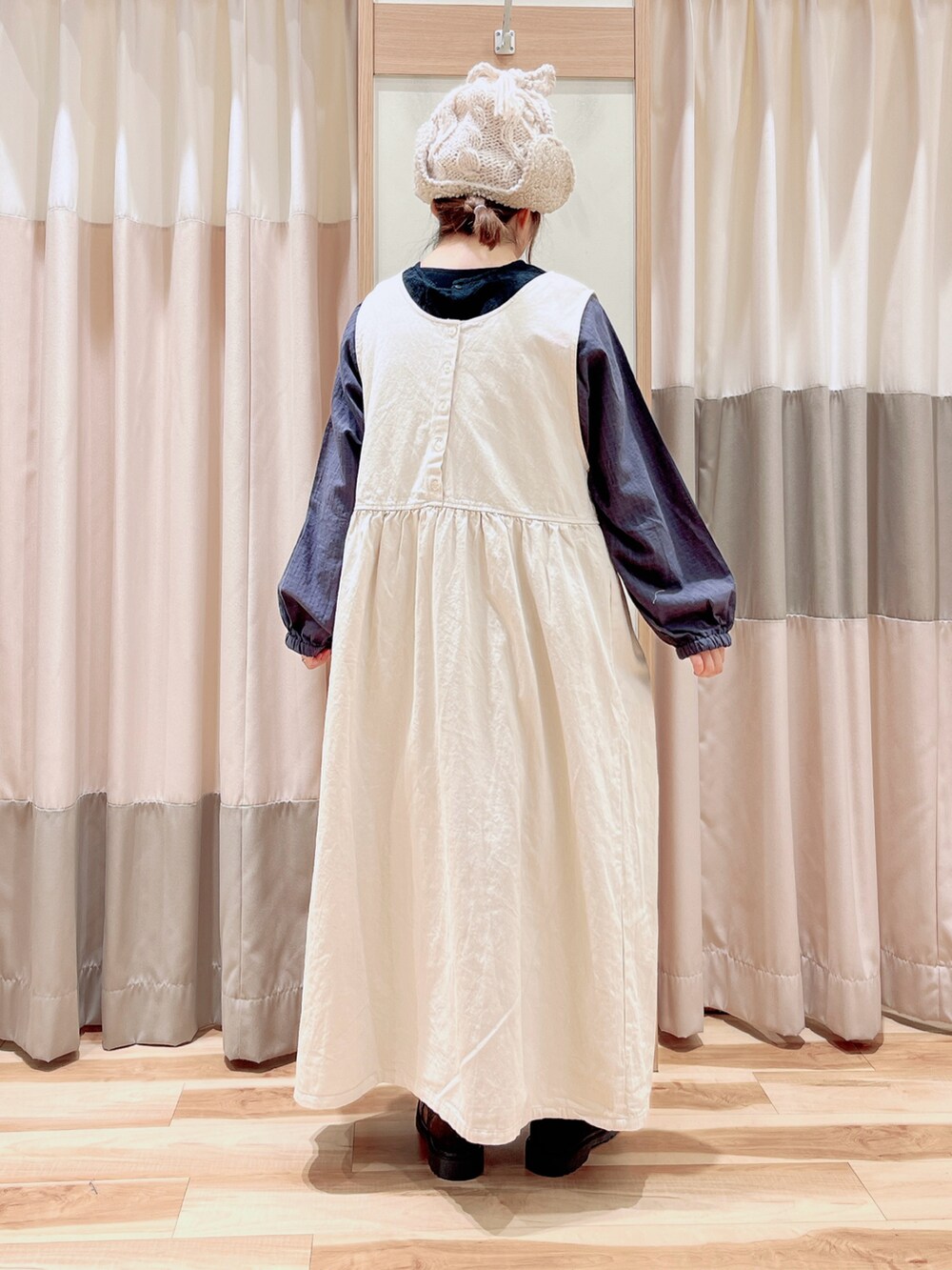 グレー系のワンピース、ホワイト系のワンピース、ブラック系のブーツを着用したレディースの冬コーディネートの2枚目の写真