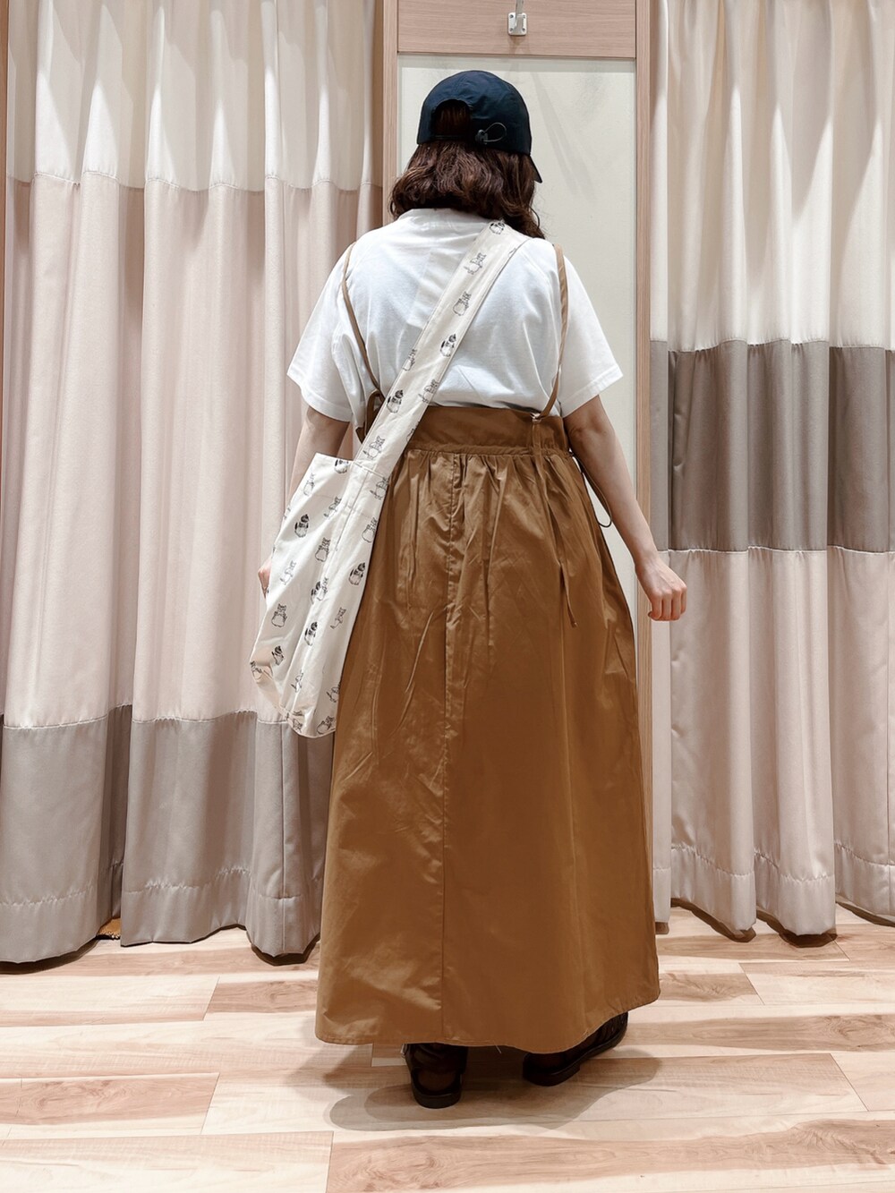 ブラウン系のワンピース、ホワイト系のハンドバッグ、ブラック系のサンダルを着用したレディースの春コーディネートの2枚目の写真