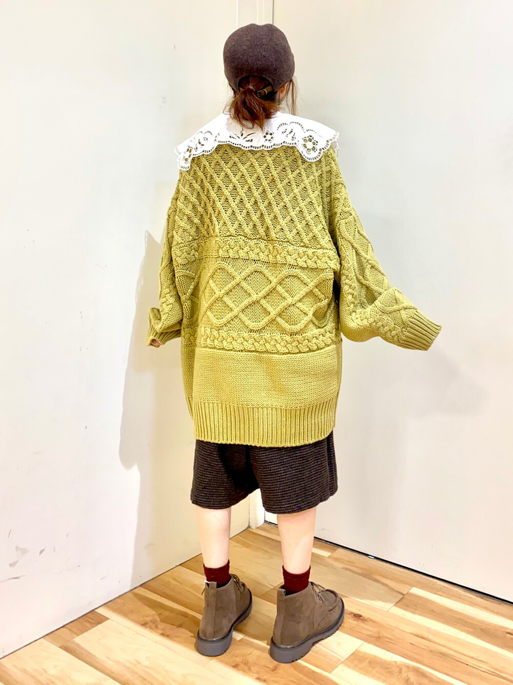 イエロー系のニット/セーター、ブラウン系のその他パンツ、ベージュ系のブーツを着用したレディースの秋コーディネートの2枚目の写真