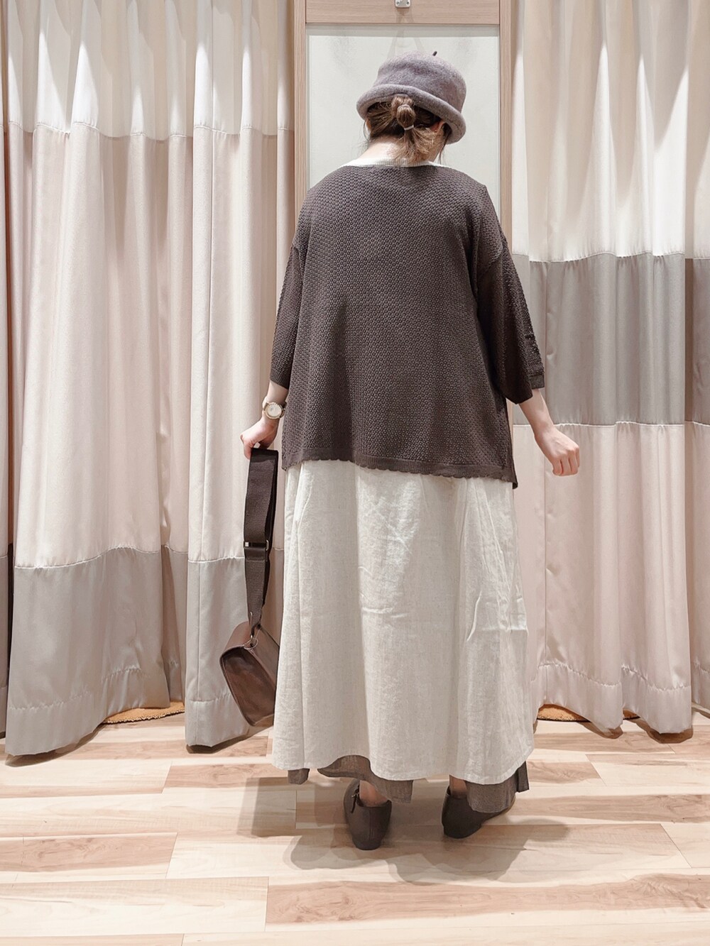 ホワイト系のワンピース、ブラウン系のカーディガン/ボレロ、ブラウン系のハンドバッグを着用したレディースの秋コーディネートの2枚目の写真