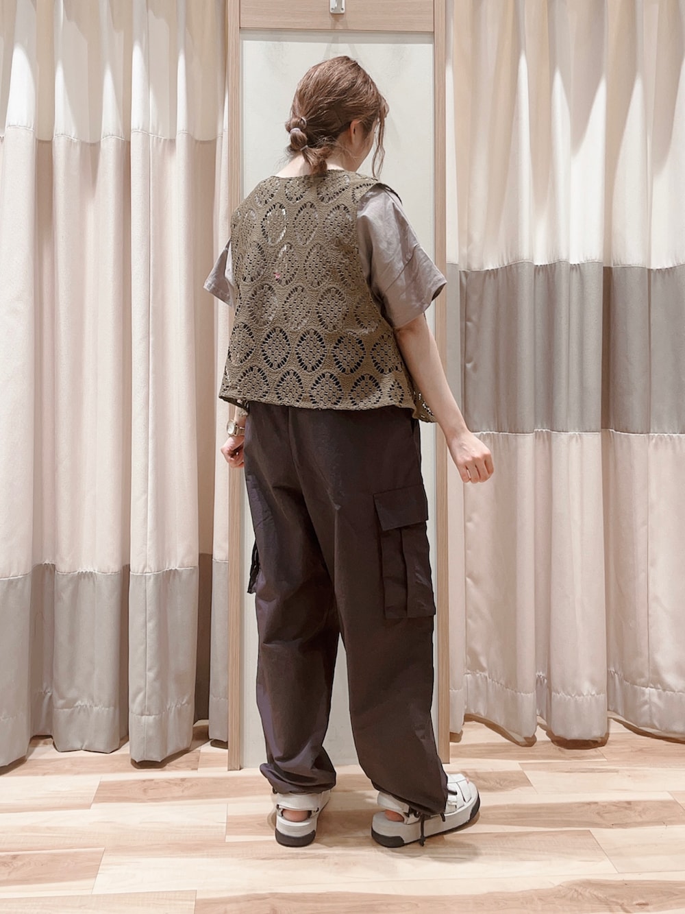 ベージュ系のTシャツ/カットソー、グリーン系のベスト、グレー系のカーゴパンツを着用したレディースの夏コーディネートの2枚目の写真