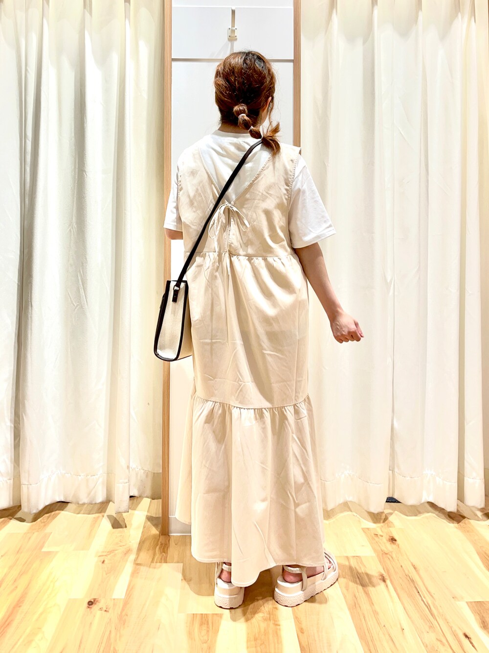 ホワイト系のニット/セーター、ホワイト系のワンピース、ブラウン系のショルダーバッグを着用したレディースの夏コーディネートの2枚目の写真