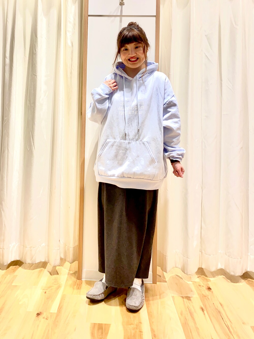 ブルー系のパーカー、グレー系のスカート、グリーン系のノーカラージャケットを着用したレディースの冬コーディネートの3枚目の写真