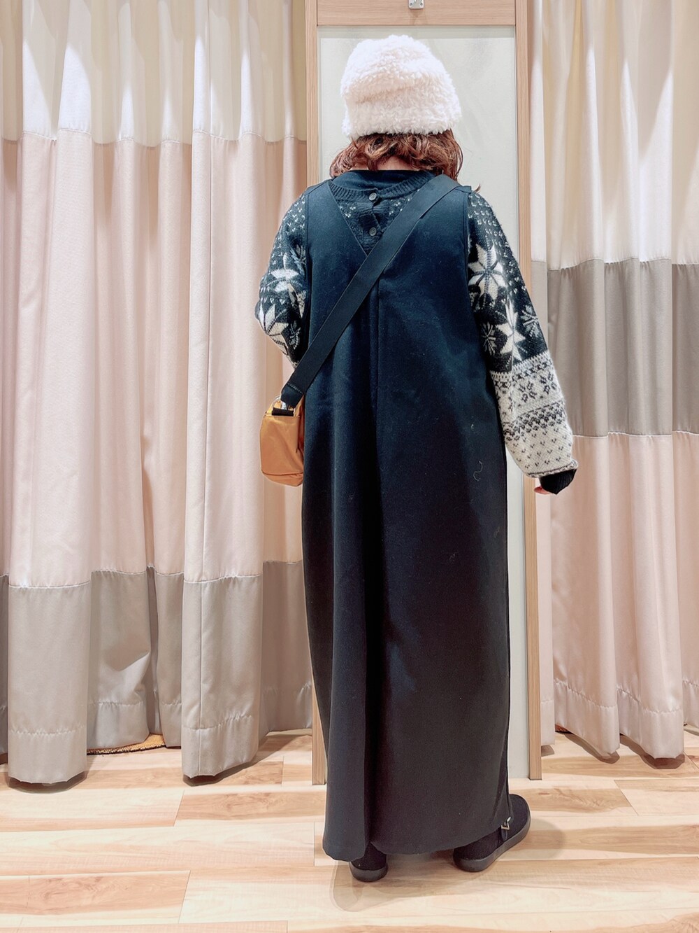 ブラック系のカーディガン/ボレロ、ブラック系のサロペット/オーバーオール、イエロー系のハンドバッグを着用したレディースの冬コーディネートの2枚目の写真