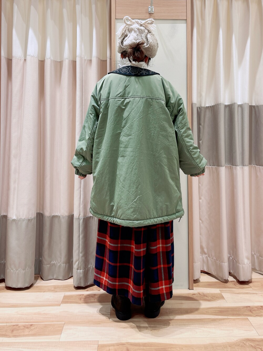 グリーン系のブルゾン、ホワイト系のシャツ/ブラウス、グレー系のカーディガン/ボレロを着用したレディースの冬コーディネートの2枚目の写真