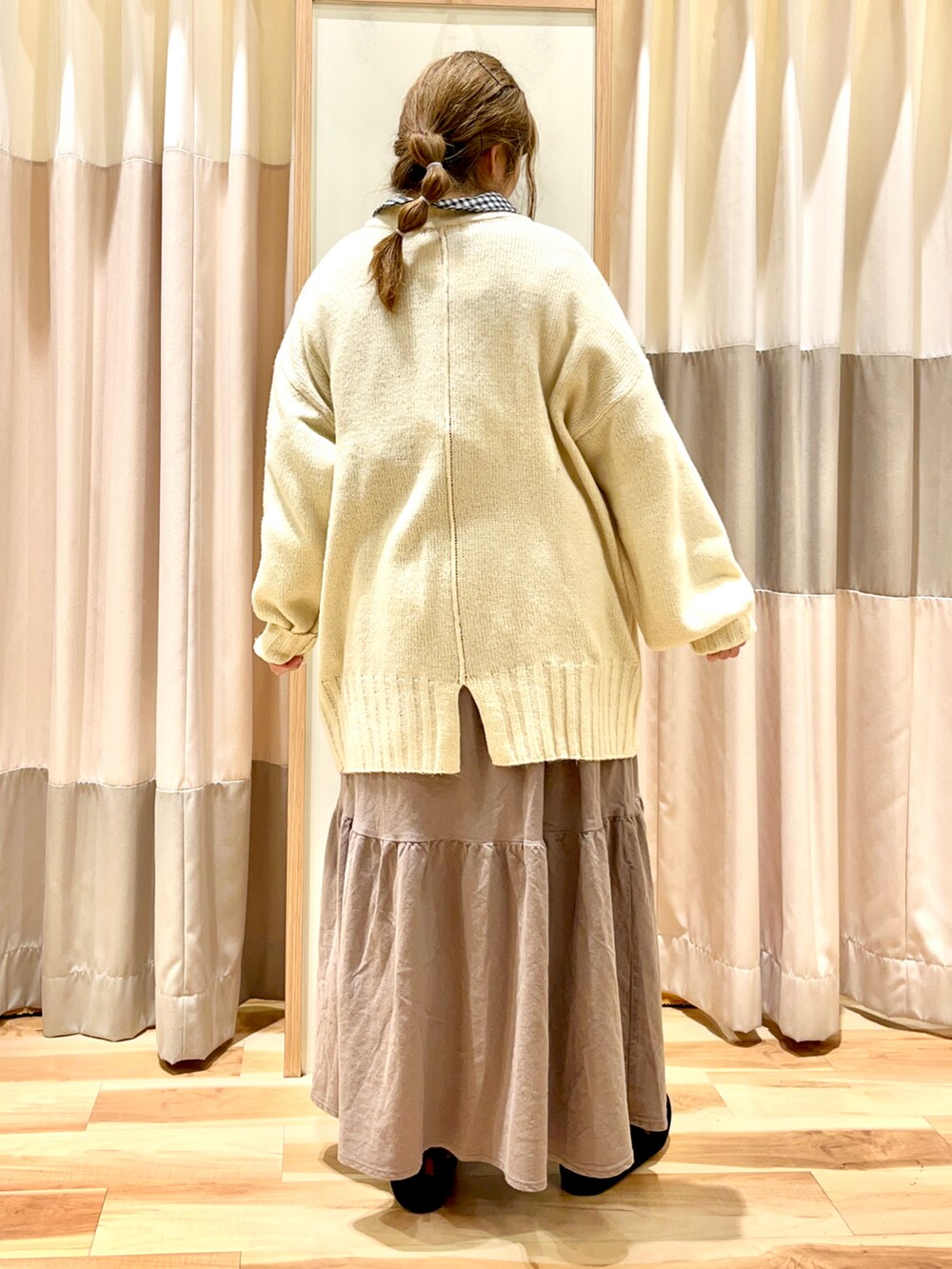 ホワイト系のニット/セーター、ブラック系のシャツ/ブラウス、ブラウン系のスカートを着用したレディースの冬コーディネートの4枚目の写真