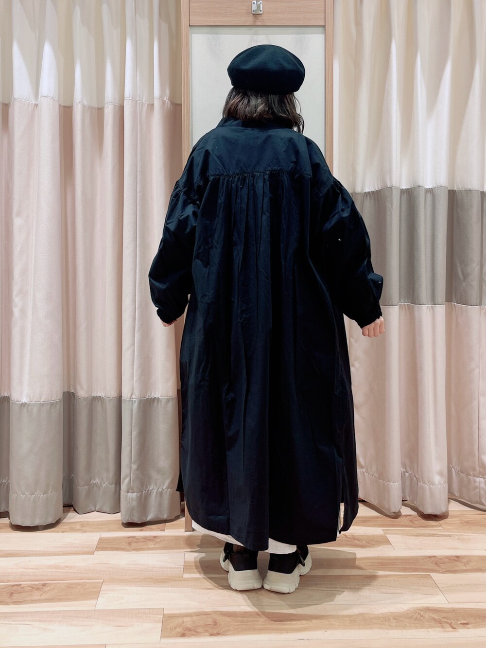 ブラック系のワンピース、ブルー系のTシャツ/カットソー、ブラック系のスニーカーを着用したレディースの春コーディネートの2枚目の写真