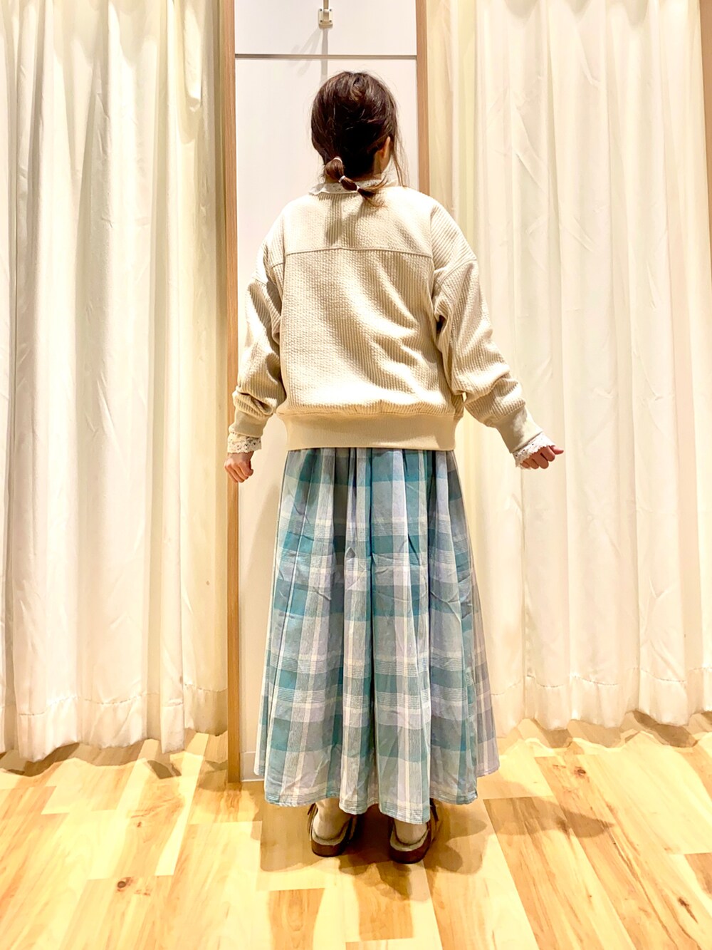 ホワイト系のカーディガン/ボレロ、ホワイト系のシャツ/ブラウス、グリーン系のスカートを着用したレディースの冬コーディネートの2枚目の写真