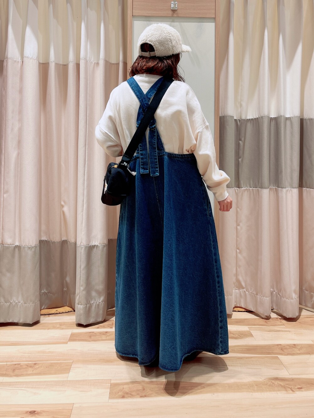 ブルー系のワンピース、ホワイト系のTシャツ/カットソー、ブラック系のハンドバッグを着用したレディースの秋コーディネートの2枚目の写真