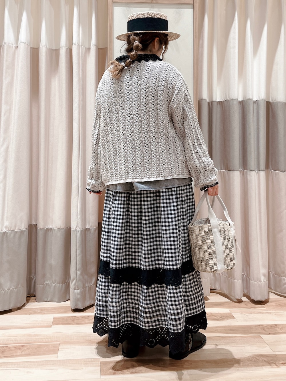 ホワイト系のカーディガン/ボレロ、ブラック系のシャツ/ブラウス、グレー系のスカートを着用したレディースの春コーディネートの2枚目の写真