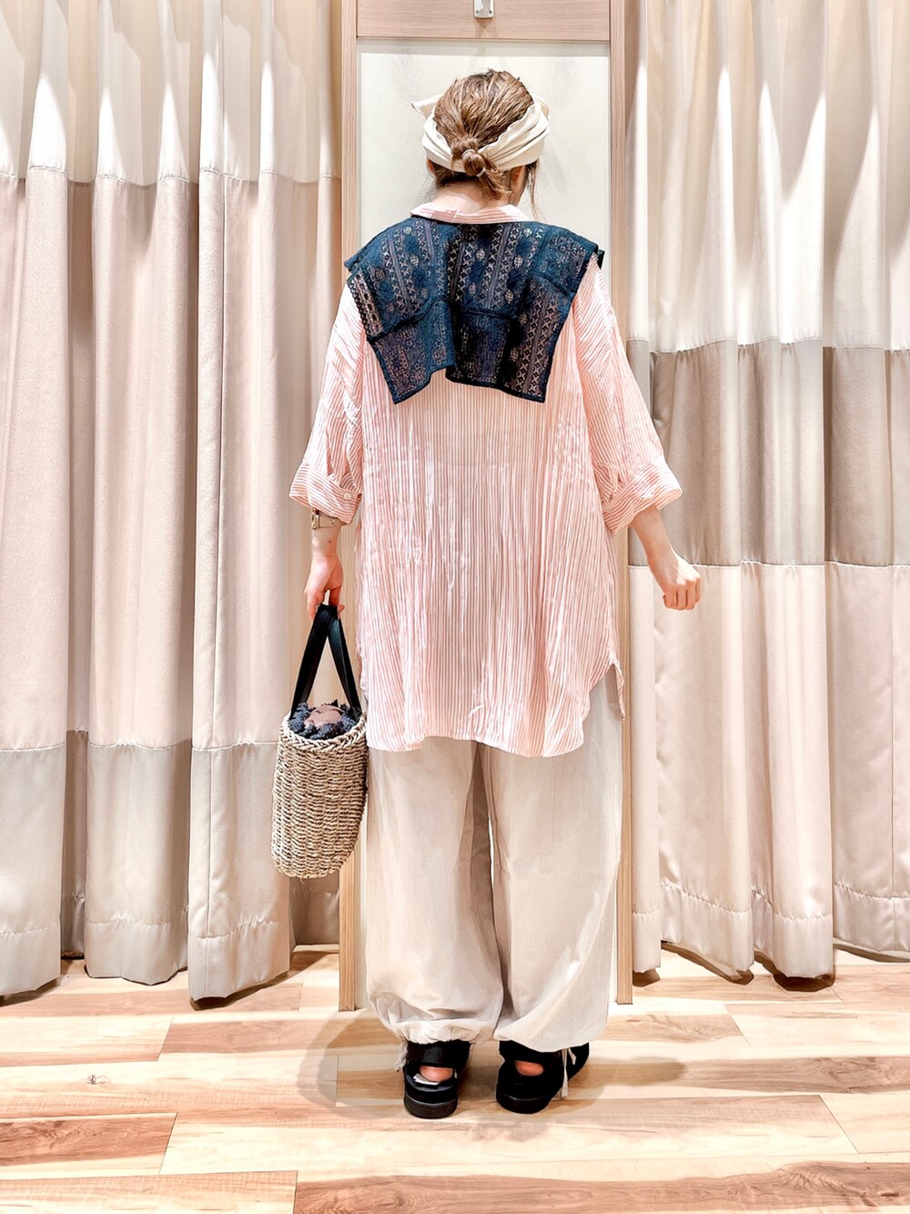 レッド系のチュニック、ブラック系のシャツ/ブラウス、ベージュ系のその他パンツを着用したレディースの夏コーディネートの2枚目の写真