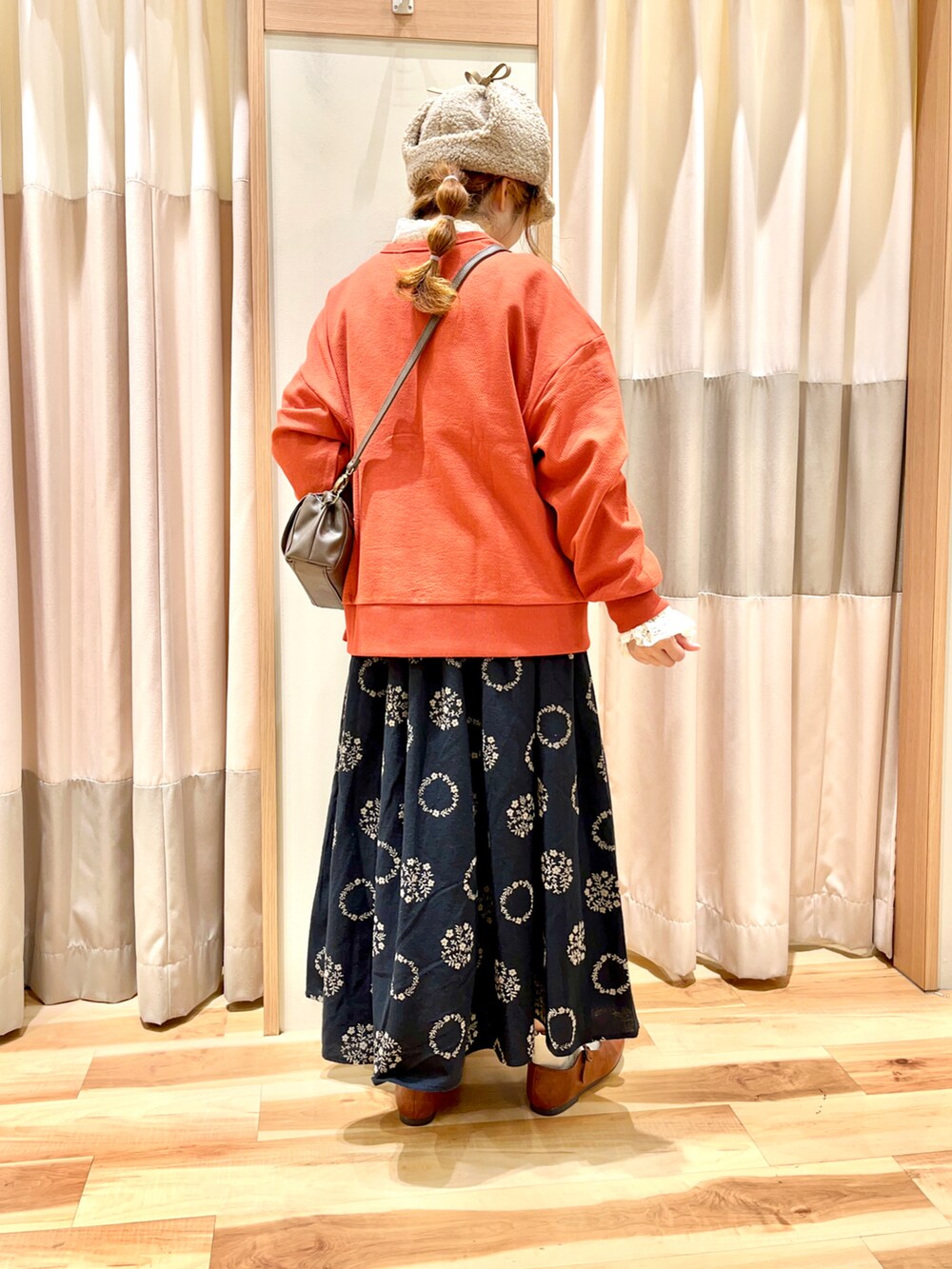 レッド系のカーディガン/ボレロ、ホワイト系のシャツ/ブラウス、ブラック系のスカートを着用したレディースの秋コーディネートの2枚目の写真