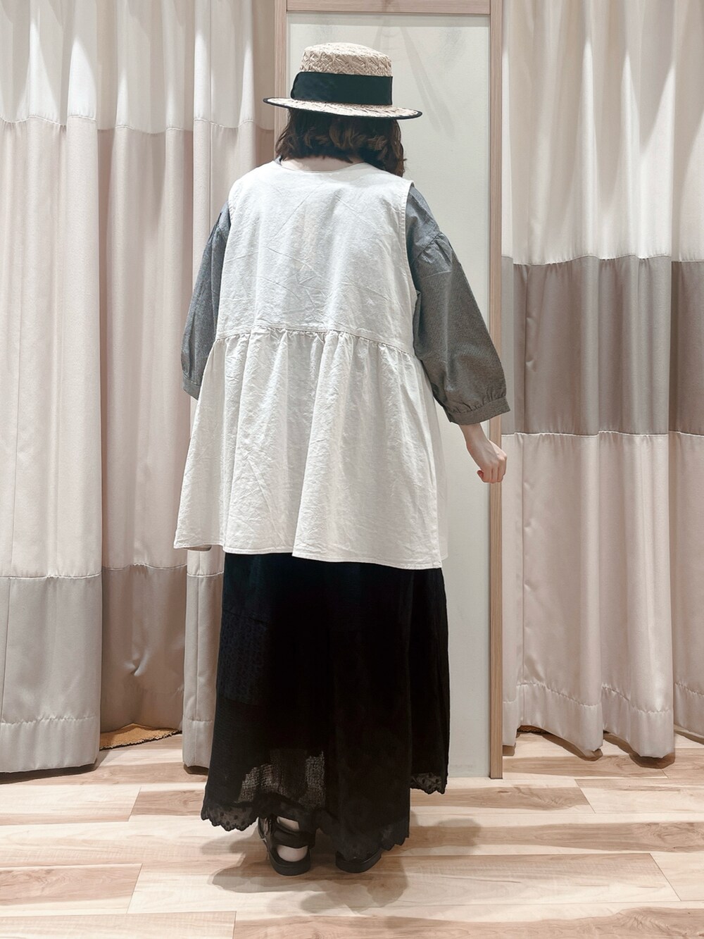 ホワイト系のベスト、グレー系のシャツ/ブラウス、ブラック系のスカートを着用したレディースの夏コーディネートの2枚目の写真