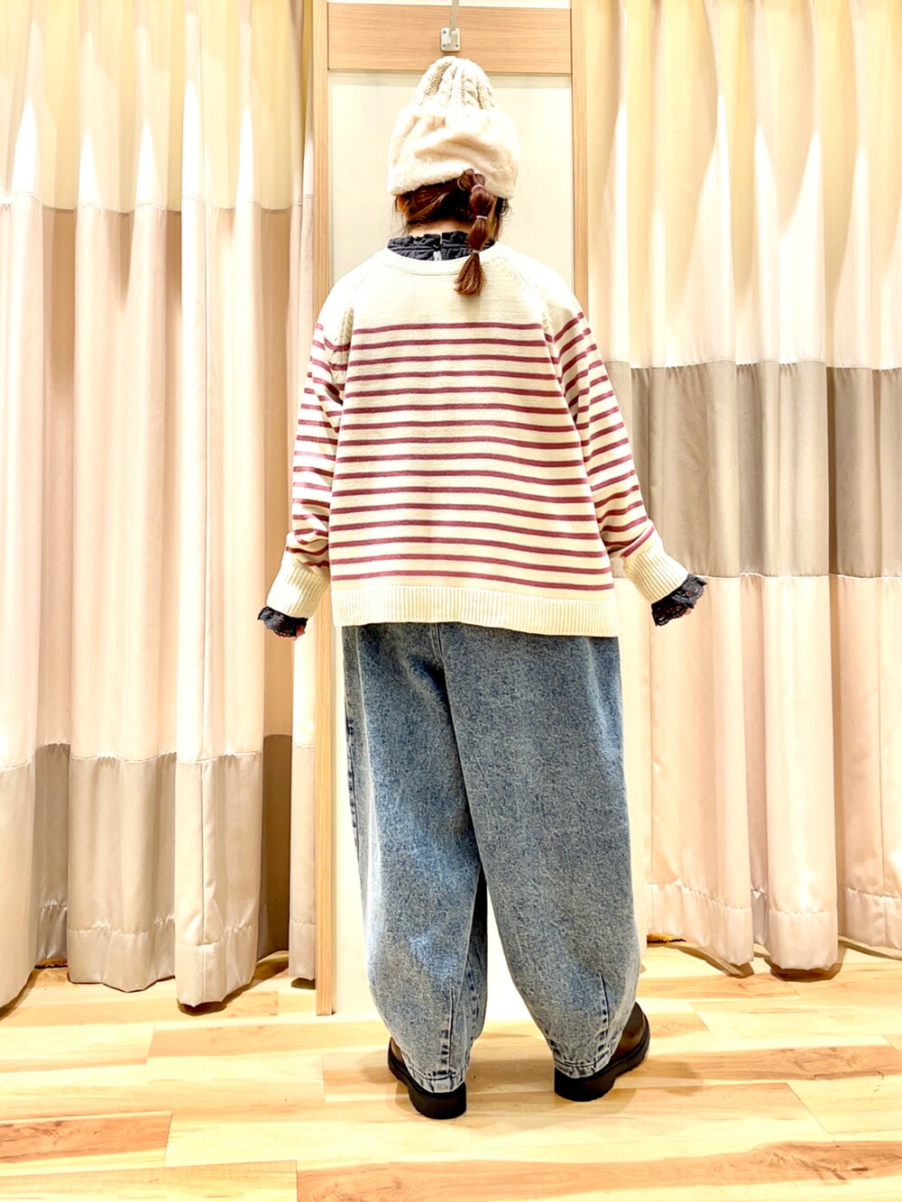 ピンク系のニット/セーター、グレー系のシャツ/ブラウス、ブルー系のデニムパンツを着用したレディースの冬コーディネートの2枚目の写真