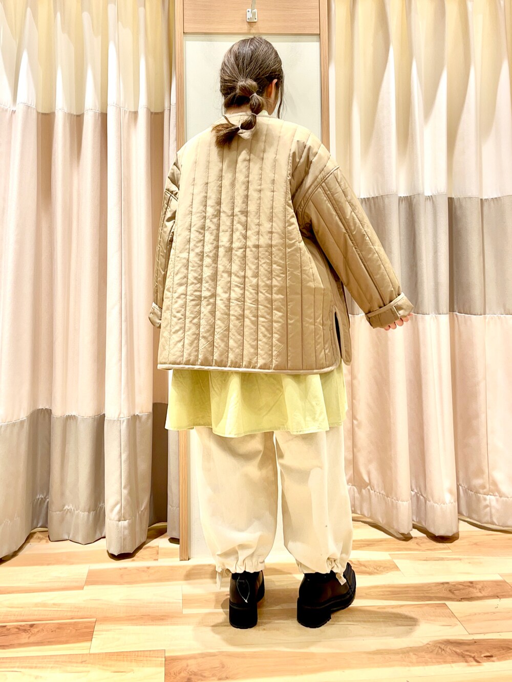 ベージュ系のノーカラージャケット、グリーン系のTシャツ/カットソー、ブルー系のその他パンツを着用したレディースの冬コーディネートの2枚目の写真