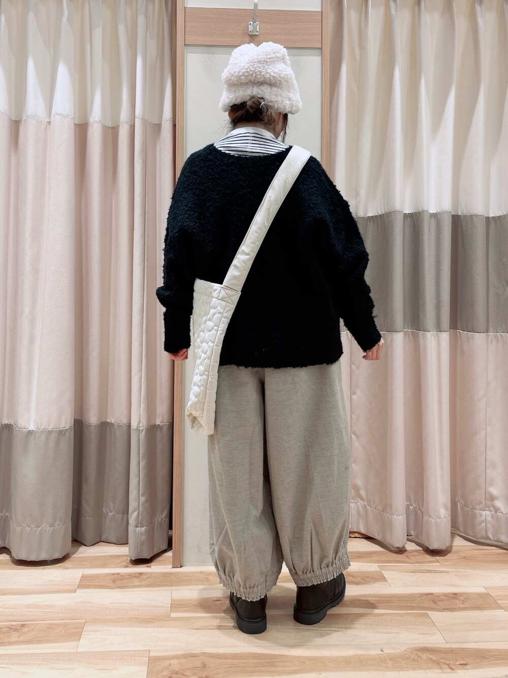 ブラック系のカーディガン/ボレロ、グレー系のその他パンツ、ホワイト系のハンドバッグを着用したレディースの冬コーディネートの2枚目の写真