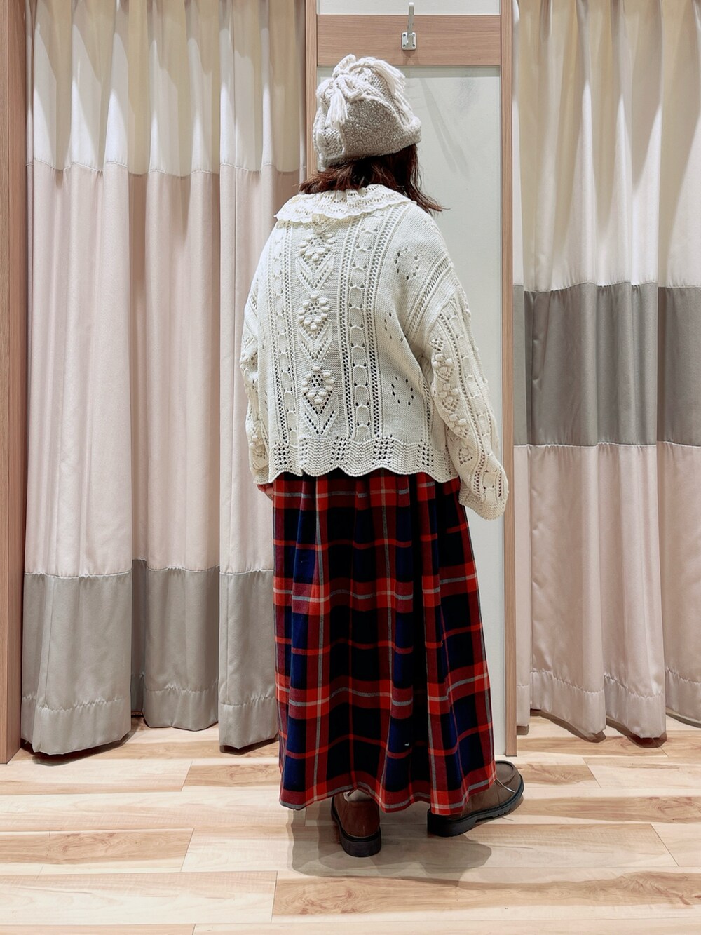 ホワイト系のシャツ/ブラウス、ホワイト系のカーディガン/ボレロ、レッド系のスカートを着用したレディースの冬コーディネートの2枚目の写真