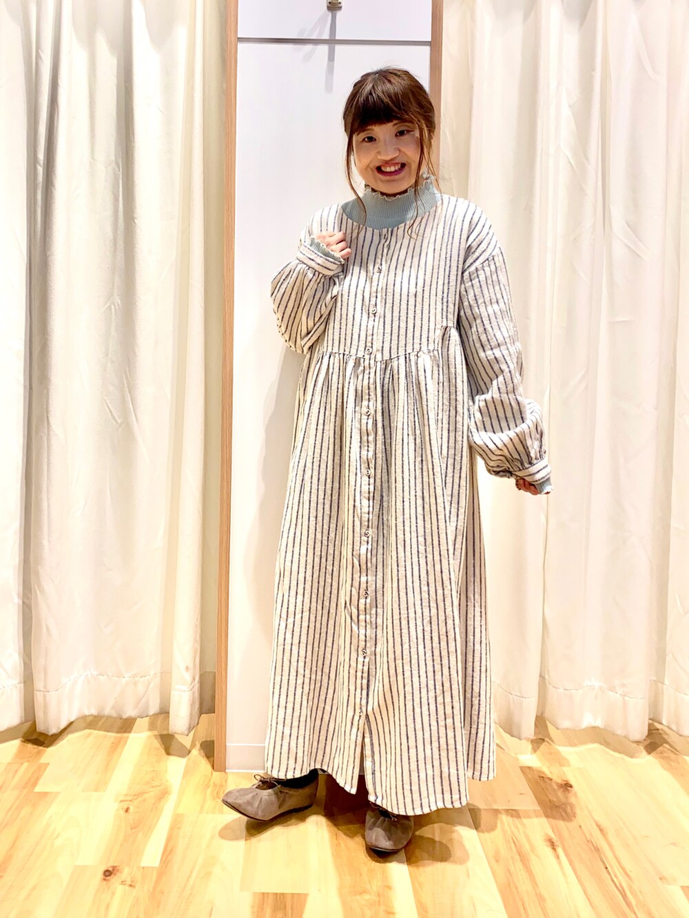 グレー系のカーディガン/ボレロ、ブルー系のワンピース、グリーン系のTシャツ/カットソーを着用したレディースの冬コーディネートの3枚目の写真