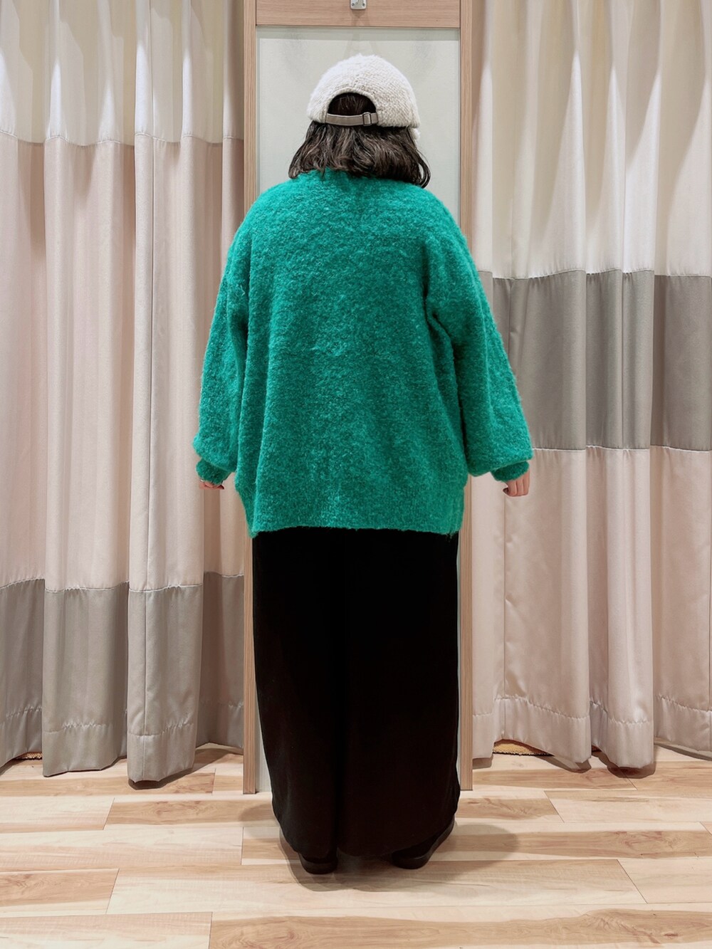 グリーン系のカーディガン/ボレロ、ブルー系のTシャツ/カットソー、ブラック系のサロペット/オーバーオールを着用したレディースの冬コーディネートの2枚目の写真