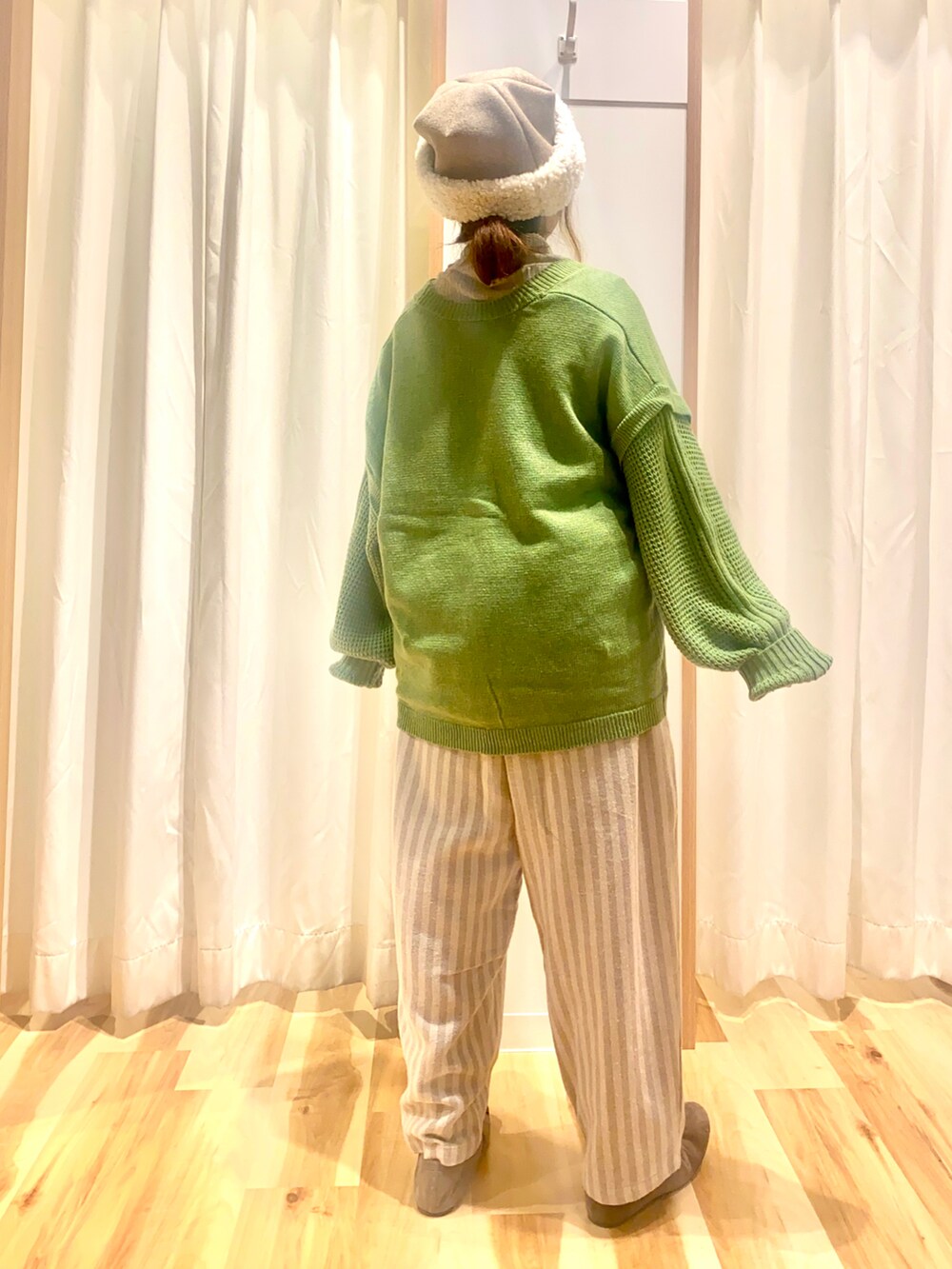 グリーン系のカーディガン/ボレロ、ベージュ系のTシャツ/カットソー、ベージュ系のその他パンツを着用したレディースの冬コーディネートの2枚目の写真