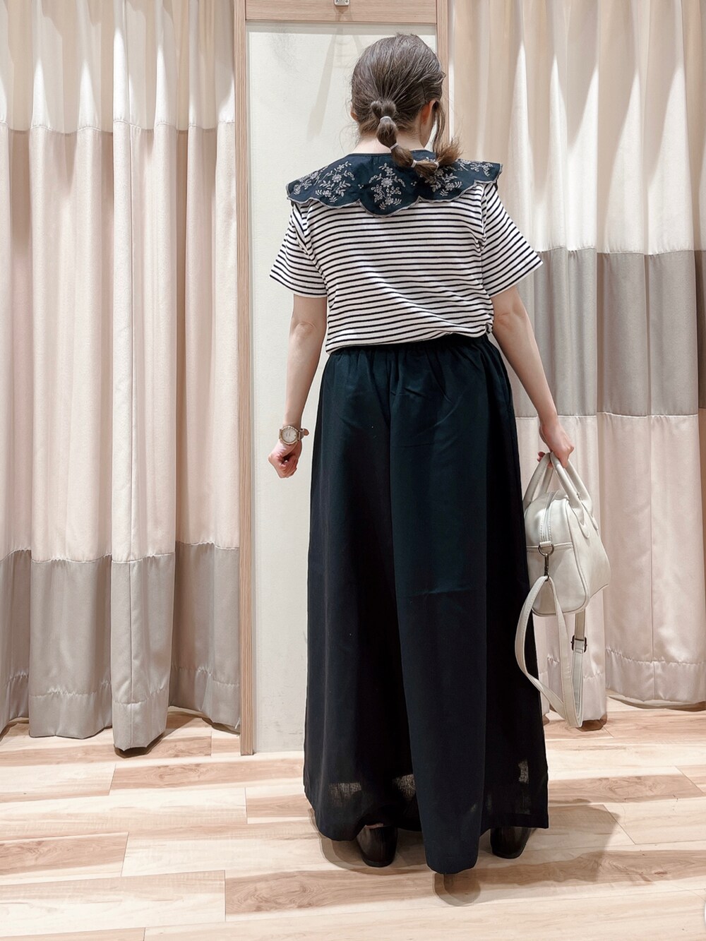 ホワイト系のTシャツ/カットソー、ブラック系のその他パンツ、ホワイト系のハンドバッグを着用したレディースの春コーディネートの2枚目の写真